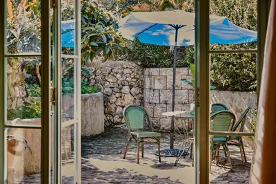 a patio with a table and chairs and an umbrella at Casa Marqués at Masia Nur Sitges, Adults only in Canyelles