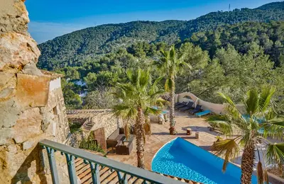 a view of a resort with palm trees and mountains at Casa Azul at Masia Nur Sitges, Adults only in Canyelles