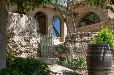 a stone house with a gate and a stone wall at Casa Olivo at Masia Nur Sitges, Adults only in Canyelles