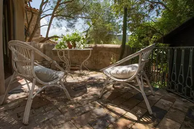 two chairs sitting on a patio next to a fence at Casa Olivo at Masia Nur Sitges, Adults only in Canyelles
