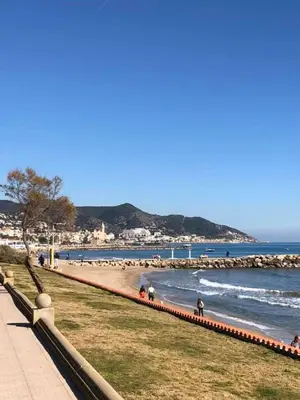 a beach with people on the sand and the water at Apartamento Montroig 2 in Sitges