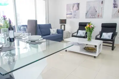 a living room with a glass table and chairs at Apartamento Montroig 2 in Sitges