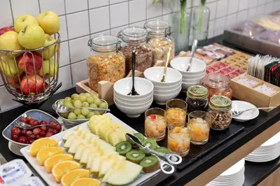 a buffet with fruits and vegetables and jars of food at Hotel Brick Barcelona in Barcelona