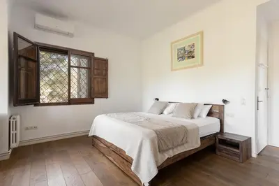 a white bedroom with a bed and a window at Luxury Villa El Turo in Castellví de Rosanés