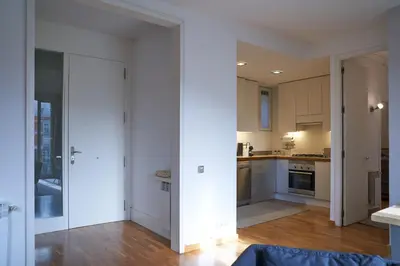 an open kitchen with white walls and wooden floors at Spacious & Comfortable flat in centric Eixample in Barcelona