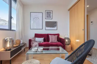 a living room with a red couch and a table at SibsBcn Downtown Penthouse in Barcelona