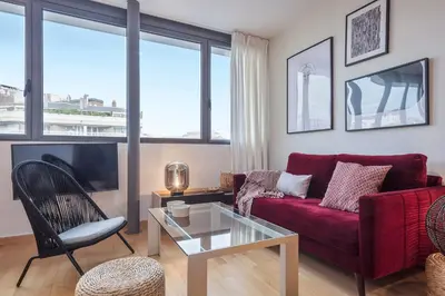 a living room with a red couch and a glass table at SibsBcn Downtown Penthouse in Barcelona