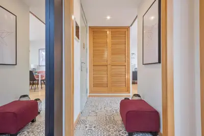 a hallway with two red chairs in front of a door at SibsBcn Downtown Penthouse in Barcelona