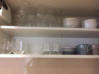 a shelf with wine glasses and plates and bowls at Sitges Centre. Simply Charming in Sitges