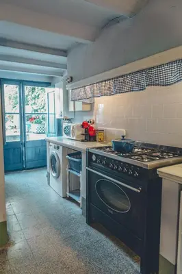 a kitchen with a stove and a washing machine at Casa Baulenas in Caldes d'Estrac