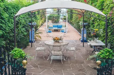a patio with a table and chairs under a gazebo at Casa Baulenas in Caldes d'Estrac