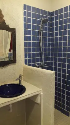 a blue tiled bathroom with a sink and a shower at BLAU in Masnou