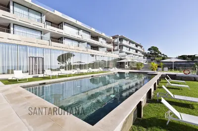 a swimming pool in front of a building at Santa Romana Apartments & Suites in Caldes d'Estrac
