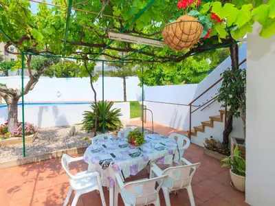 a table and chairs on a patio with a pool at Holiday Home Katy by Interhome in Cunit