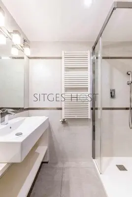 a white bathroom with a sink and a shower at A 20 metros de la playa in Sitges
