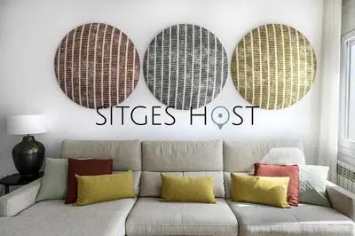 a living room with a couch and three baskets on the wall at A 20 metros de la playa in Sitges