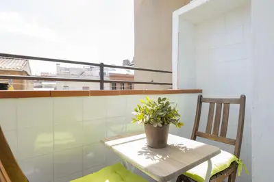 a small table with a potted plant on a balcony at Housalia Guell & Gracia in Barcelona