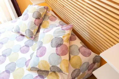 a bed with polka dot pillows on it at Housalia Guell & Gracia in Barcelona