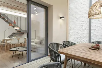 a dining room and living room with a table and chairs at Ola Living Calabria in Barcelona
