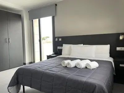 a bedroom with a bed with three towels on it at 6 Bis HOTEL in Castelldefels