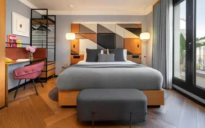 a bedroom with a bed and a desk and a chair at Kimpton Vividora Hotel by IHG in Barcelona
