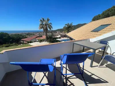 a table and chairs on the roof of a house at Palm Maresme - Suite with bathroom and terrasse with ocean views in a private villa in Vilassar de Dalt