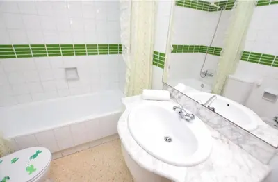 a bathroom with a toilet and a sink and a tub at Apartamento Pineda in Pineda de Mar