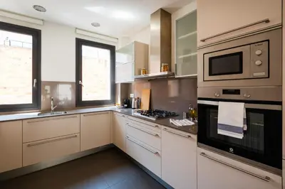 a kitchen with white cabinets and a stove top oven at Petit Luxe Tobella Dreta in Terrassa