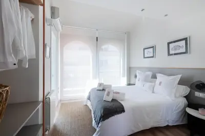 a white bedroom with a large white bed with white pillows at Petit Luxe Tobella Dreta in Terrassa