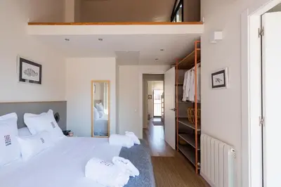 a bedroom with a large white bed with white pillows at Petit Luxe Tobella Dreta in Terrassa