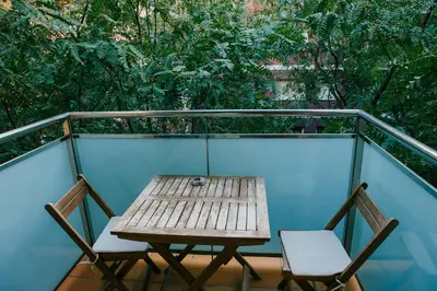 a wooden table and two chairs on a balcony at Apartamentos Navas in Barcelona