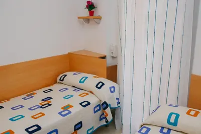 a small bedroom with a bed with a crib at Apartamentos Navas in Barcelona