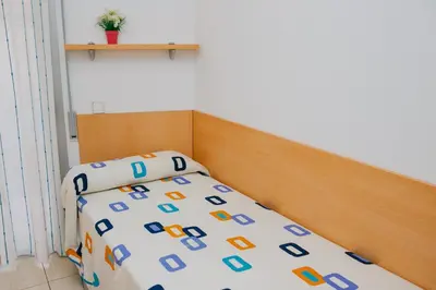 a bedroom with a bed with a wooden head board at Apartamentos Navas in Barcelona