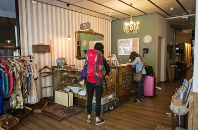 a woman standing at a counter in a clothing store at Pars Tailor's Hostel in Barcelona