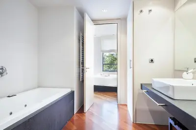 a bathroom with a tub and two sinks and a mirror at Uma Suites Passeig de Gracia 16 in Barcelona
