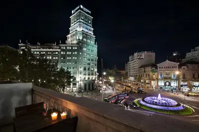 a view of a city at night with a building at Uma Suites Passeig de Gracia 16 in Barcelona