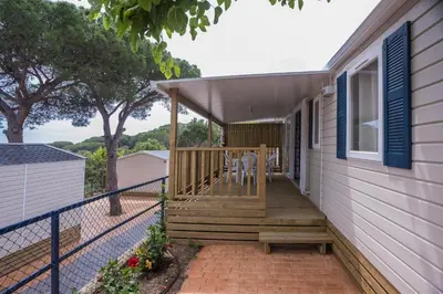 a porch of a house with two chairs on it at Camping Roca Grossa in Calella