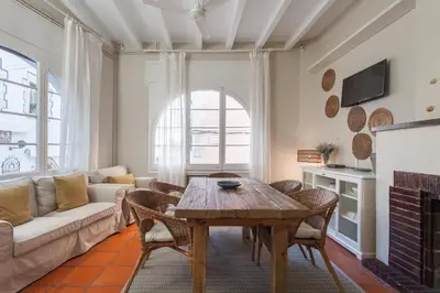 a living room with a table and a couch at La Casita - centro histórico y playa in Sitges