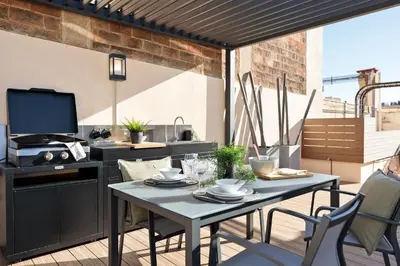 a patio with a table and chairs on a balcony at Apartments Barcelona & Home Deco Eixample in Barcelona