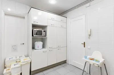 a white kitchen with white cabinets and a microwave at Large & beautiful apartment 4min from Passeig de Gràcia in Barcelona