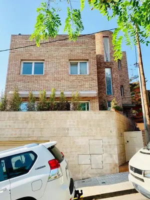 a white car parked in front of a brick building at Barcelona Village Homestay in Tiana