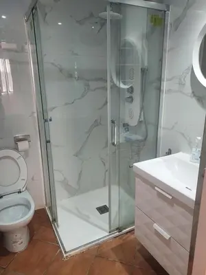 a bathroom with a shower and a toilet and a sink at Barcelona Village Homestay in Tiana