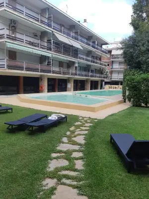 a large building with a swimming pool in the yard at Apart.con piscina en Sitges zona residencial in Sitges