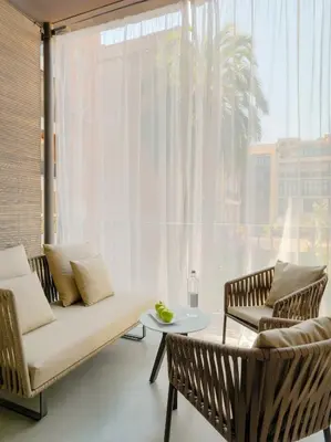 a living room with a couch and chairs and a large window at H10 Urquinaona Plaza in Barcelona