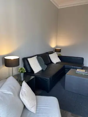 a living room with a black couch and a table at 555 Apartments BCN in Barcelona