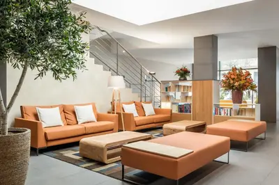 a lobby with orange furniture and a staircase at Petit Palace Trencadís in Barcelona