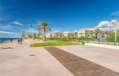 a sidewalk next to a beach with buildings and the ocean at HomeHolidaysRentals Frida in Pineda de Mar