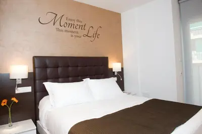 a bedroom with a bed with a sign on the wall at Home to Home Barcelona in Barcelona