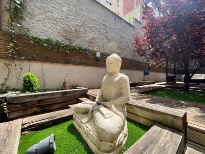 a statue of a person sitting on a bench at Home to Home Barcelona in Barcelona