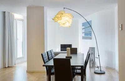 a dining room with a table and a floor lamp at Durlet Beach Apartments in Barcelona